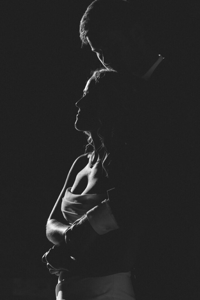 moody black and white couple embracing
