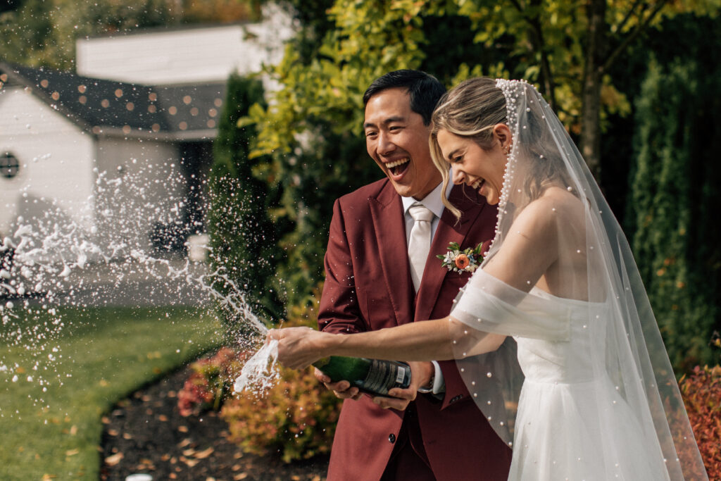 popping champagne on their wedding day