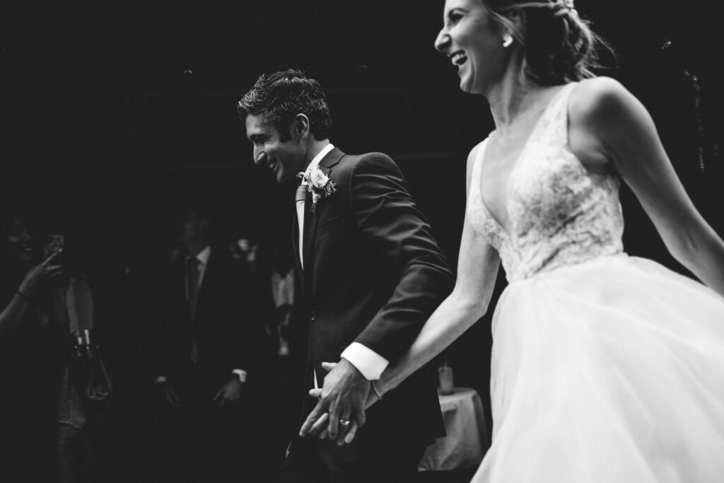 artistic black and white wedding photo of couple running